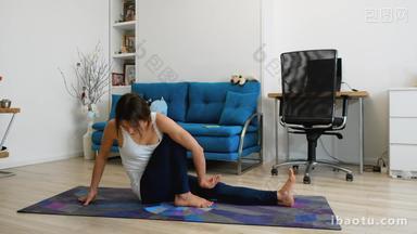 Young woman does yoga at home, sits in marichi pose